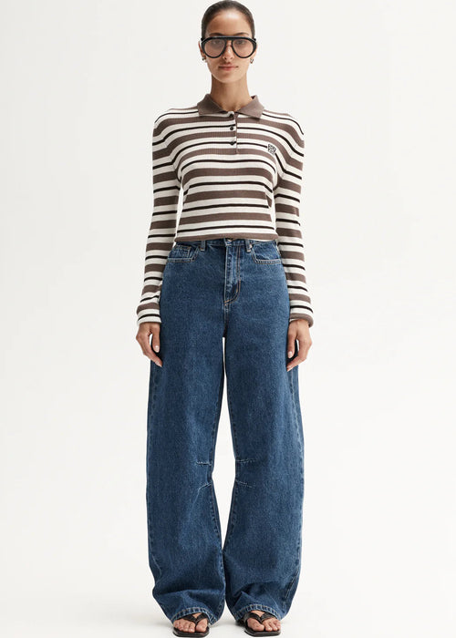 Person wearing a striped shirt and blue jeans on a white background