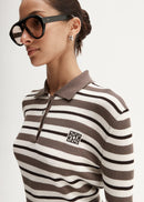 Woman wearing a brown and white striped sweater with a logo on a white background