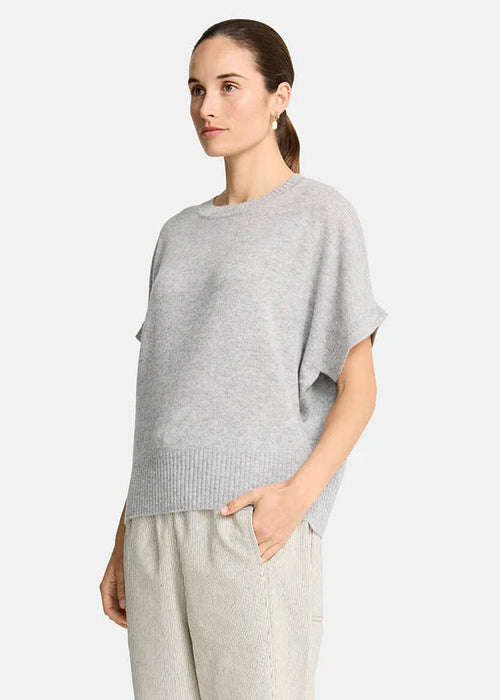 Woman wearing a grey sweater  on a white background
