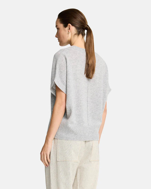 Woman wearing a grey sweater  on a white background