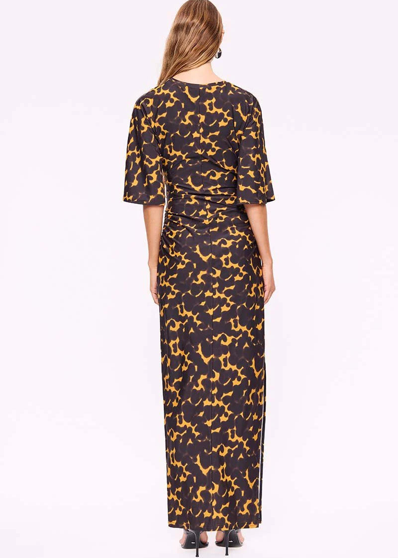 Woman wearing a black dress with yellow pattern on a white background
