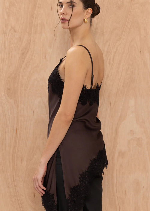 Woman wearing a black lace dress against a wooden background