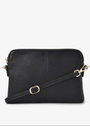 Black leather crossbody bag with gold accents on a white background