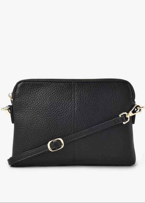 Black leather crossbody bag with gold accents on a white background