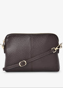 Brown leather crossbody bag with gold accents on a white background