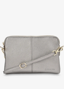 A light grey pebbled leather crossbody bag with gold-tone hardware and a matching shoulder strap, shown against a plain white background.
