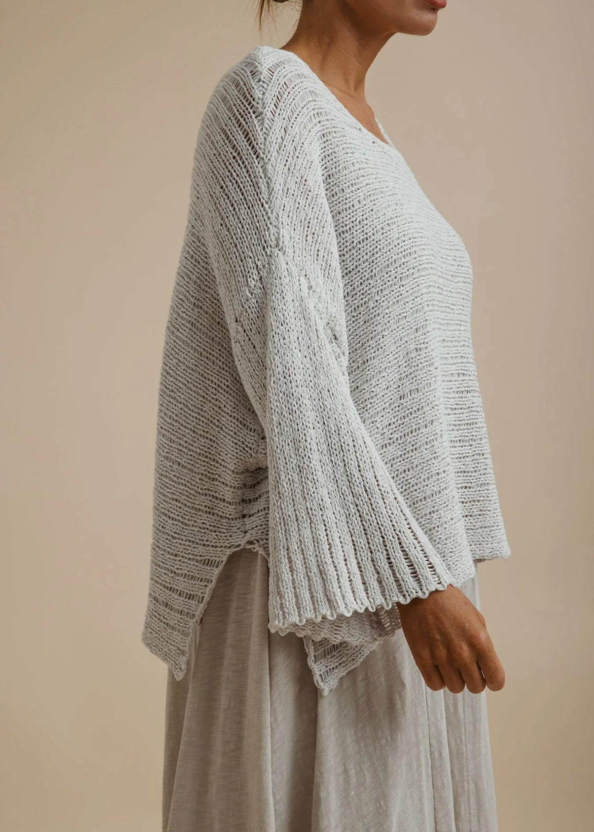 Woman weary silver knitted top on beige background