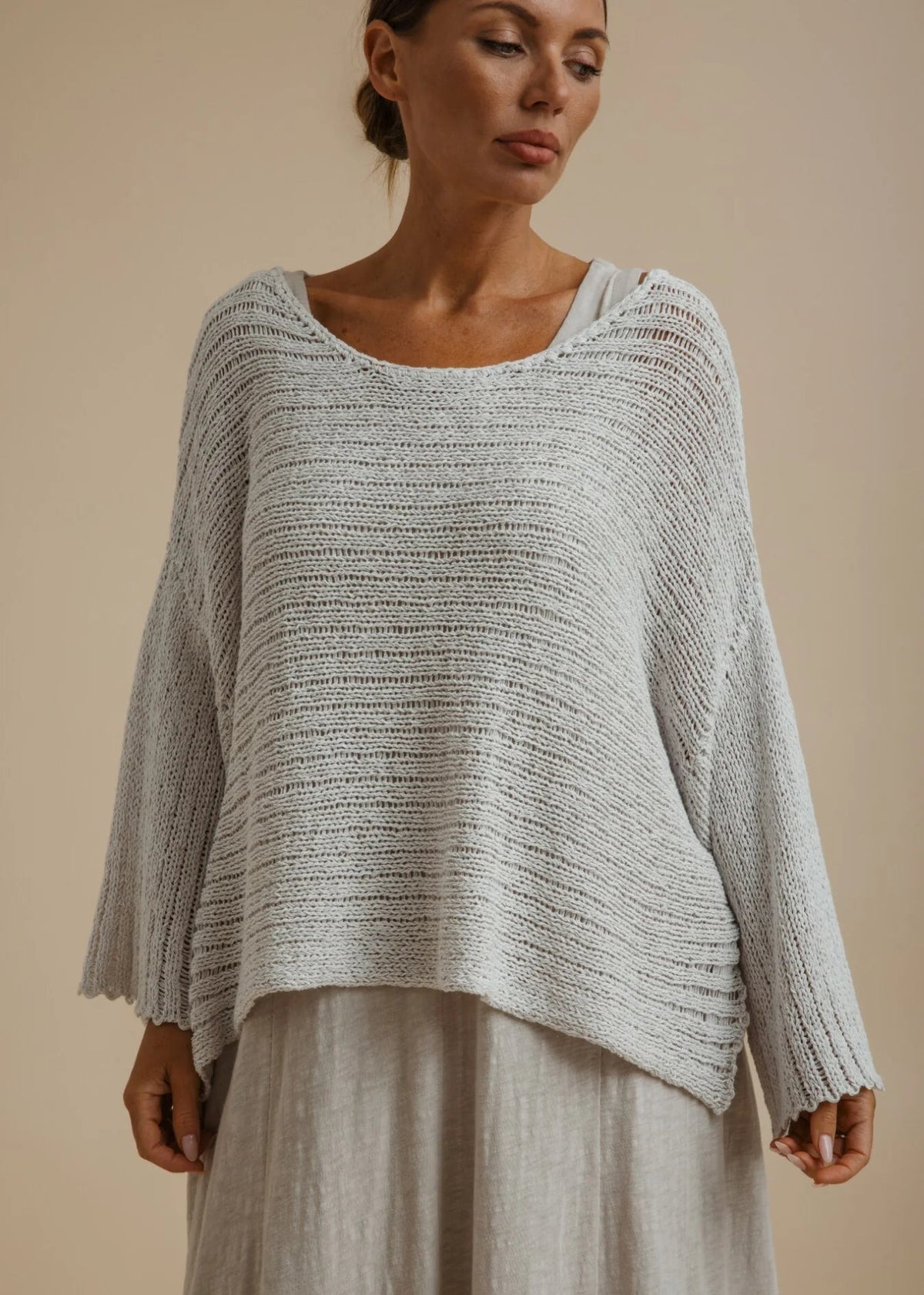 Woman weary silver knitted top on beige background