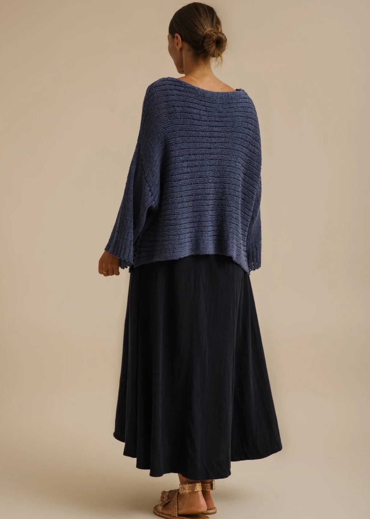 Woman wearing a blue knitted sweater on a beige background