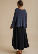 Woman wearing a blue knitted sweater on a beige background