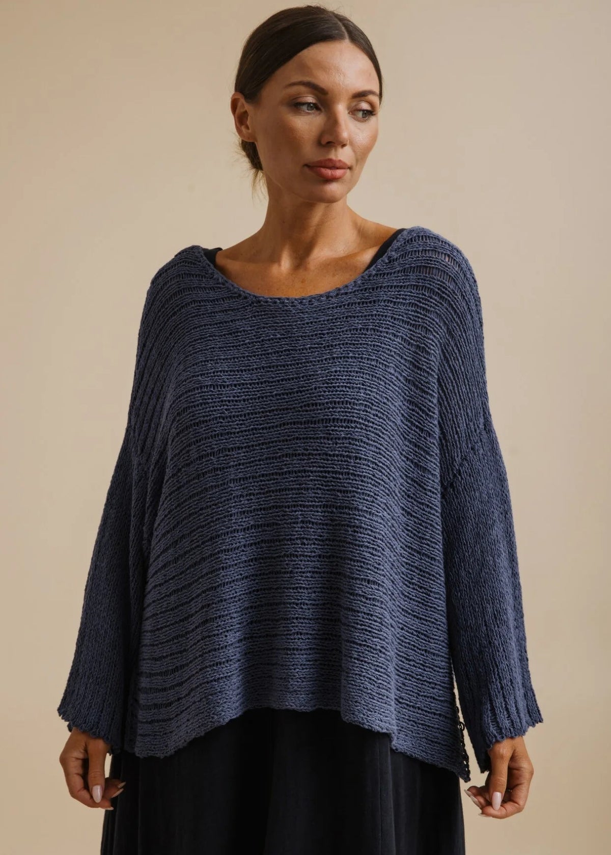 Woman wearing a blue knitted sweater on a beige background