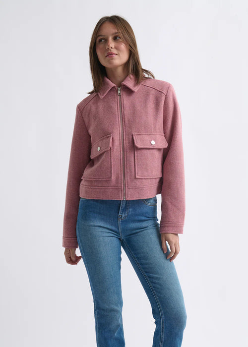 Woman wearing a pink jacket and blue jeans on a white background