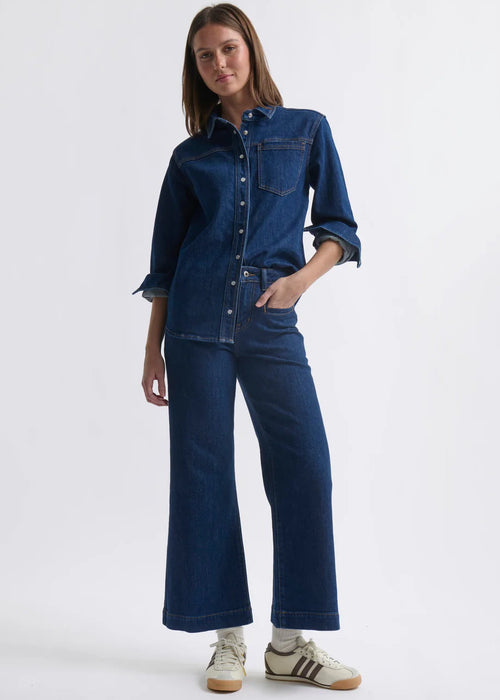 Person wearing a blue denim outfit on a white background