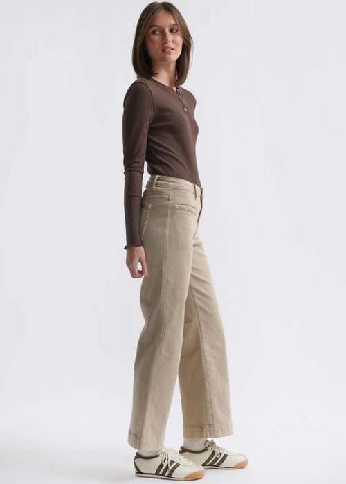 Woman wearing beige jeans on white background
