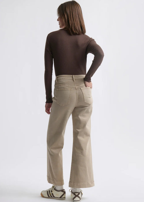 Woman wearing beige jeans on white background
