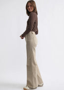 Woman wearing beige jeans on white background