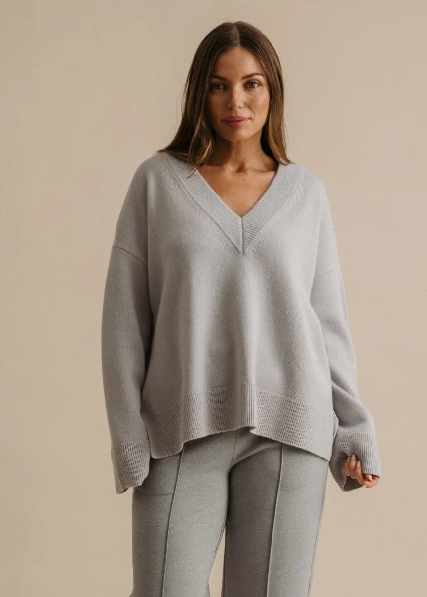 Woman wearing a light grey outfit on a beige background