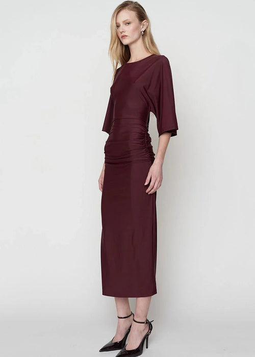 Woman wearing a burgundy dress on a white background