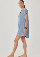 Woman wearing a blue denim dress on a plain background