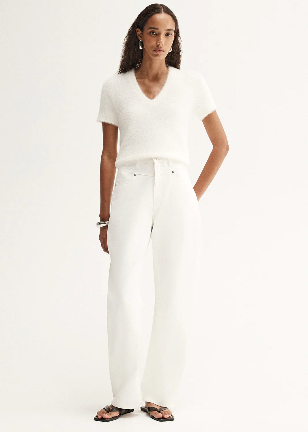 Woman wearing a white t-shirt and white pants on a white background