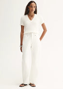 Woman wearing a white t-shirt and white pants on a white background