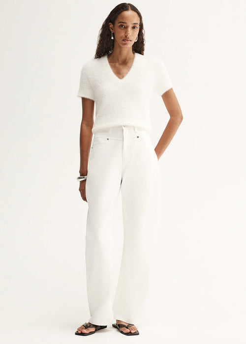 Woman wearing a white t-shirt and white pants on a white background