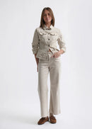 Woman wearing a beige denim jacket and pants on a white background
