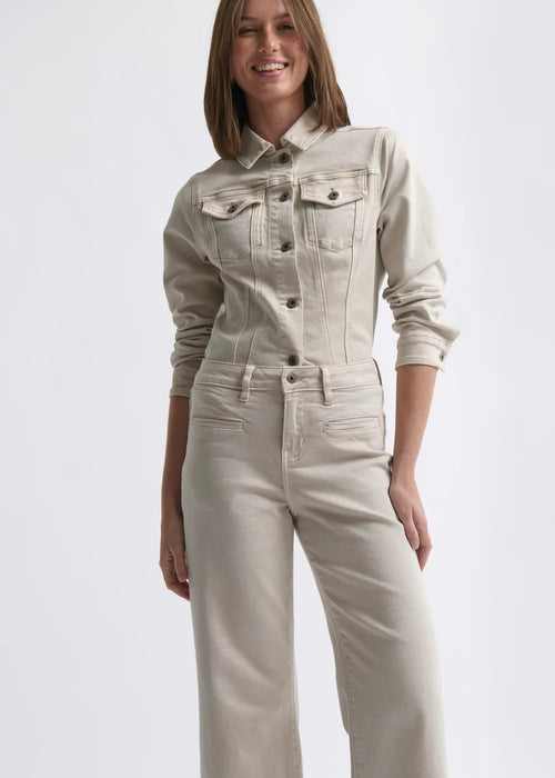 Woman wearing a beige denim jacket and pants on a white background