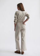 Woman wearing a beige jumpsuit on a white background