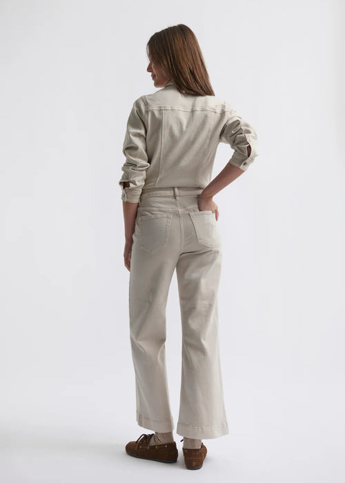 Woman wearing a beige jumpsuit on a white background