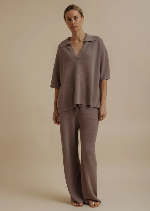 Woman modelling brown tie pants on beige background