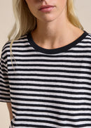 Woman wearing black and whit T- Shirt with a beige background