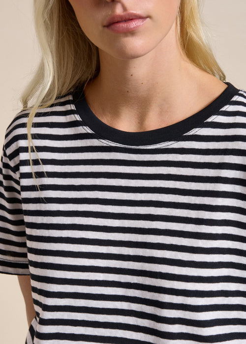 Woman wearing black and whit T- Shirt with a beige background
