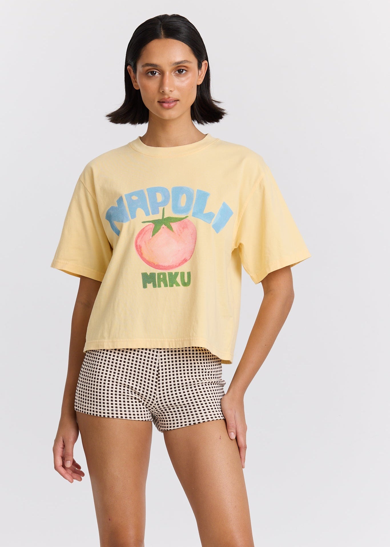 Woman wearing a yellow t-shirt with a graphic design on a white background