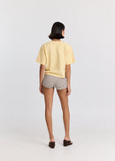 Person wearing a yellow t-shirt and checkered shorts on a white background

Details