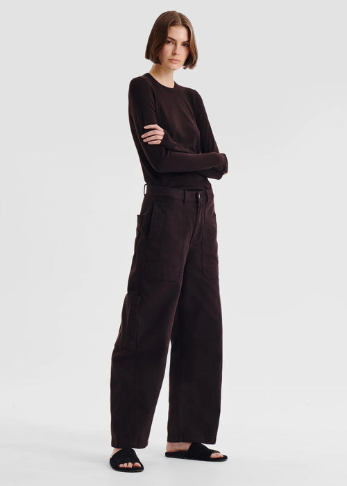 Person wearing a dark brown outfit on a white background