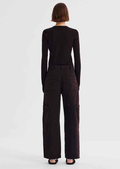 Person wearing a dark brown outfit on a white background