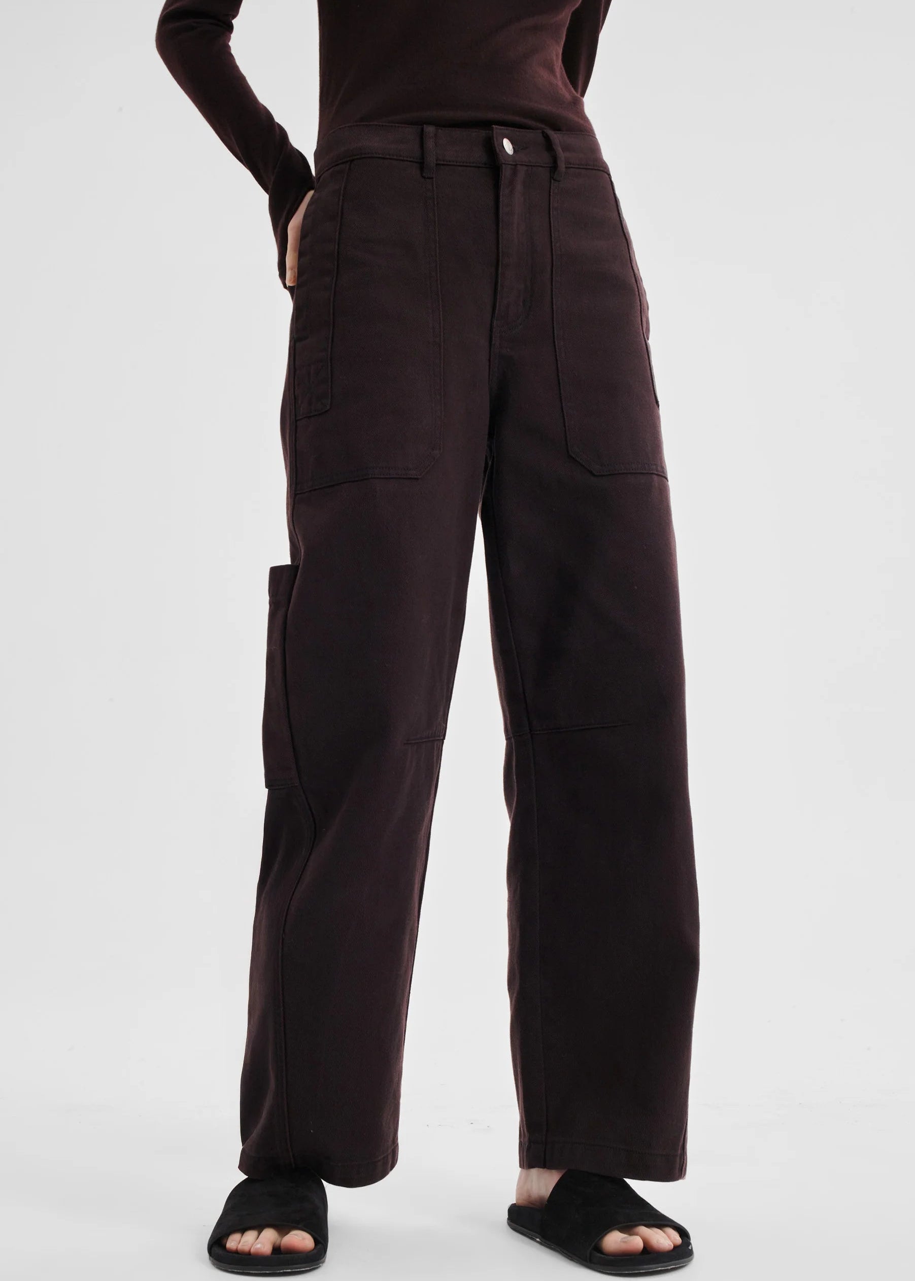 Brown pants worn by a person on a white background