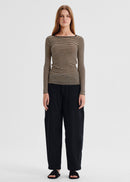 Woman wearing a striped long-sleeve top and black pants on a white background