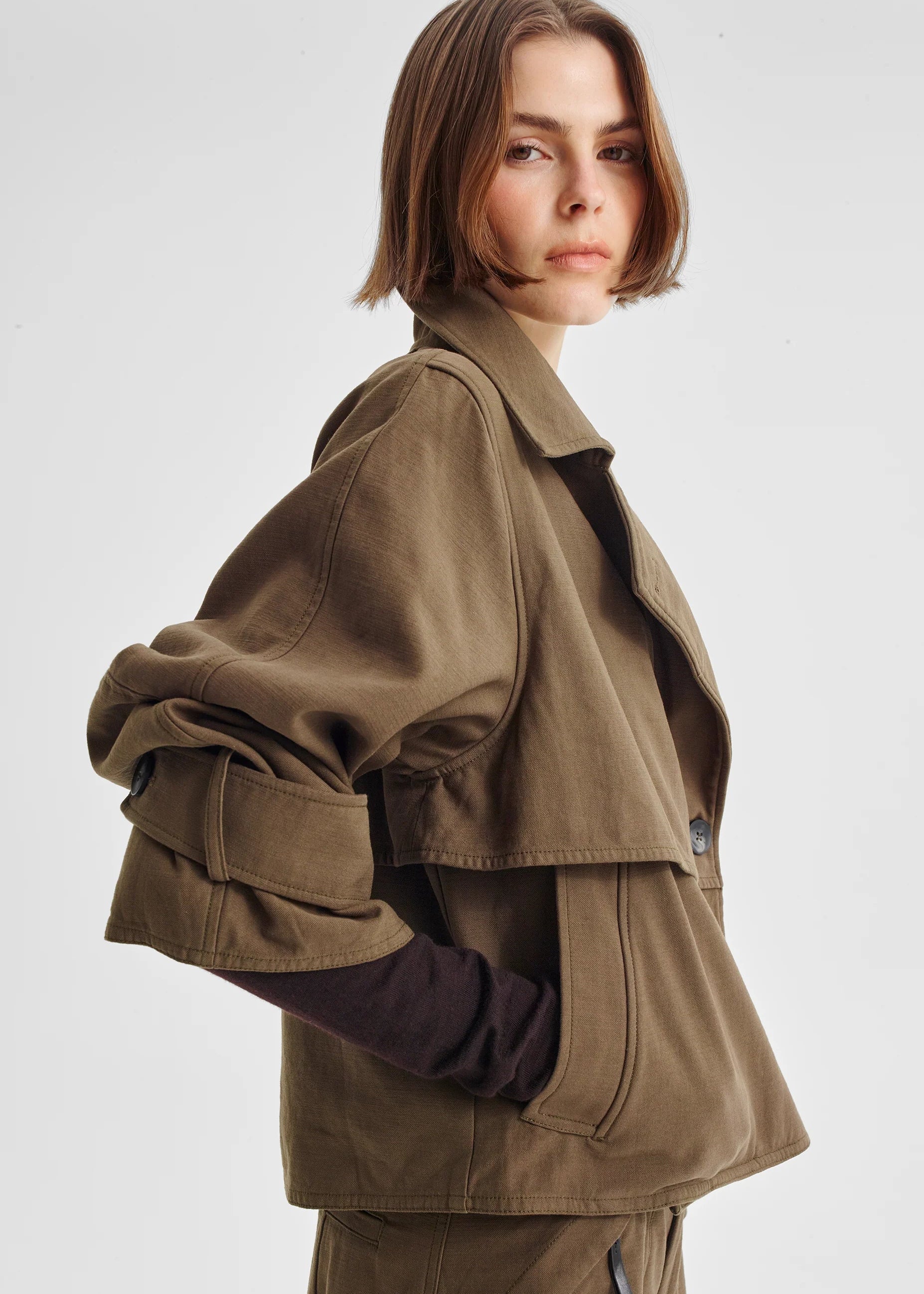 Woman wearing a brown coat on a white background