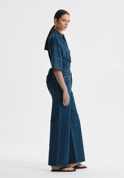 Woman wearing a blue denim top on a white background