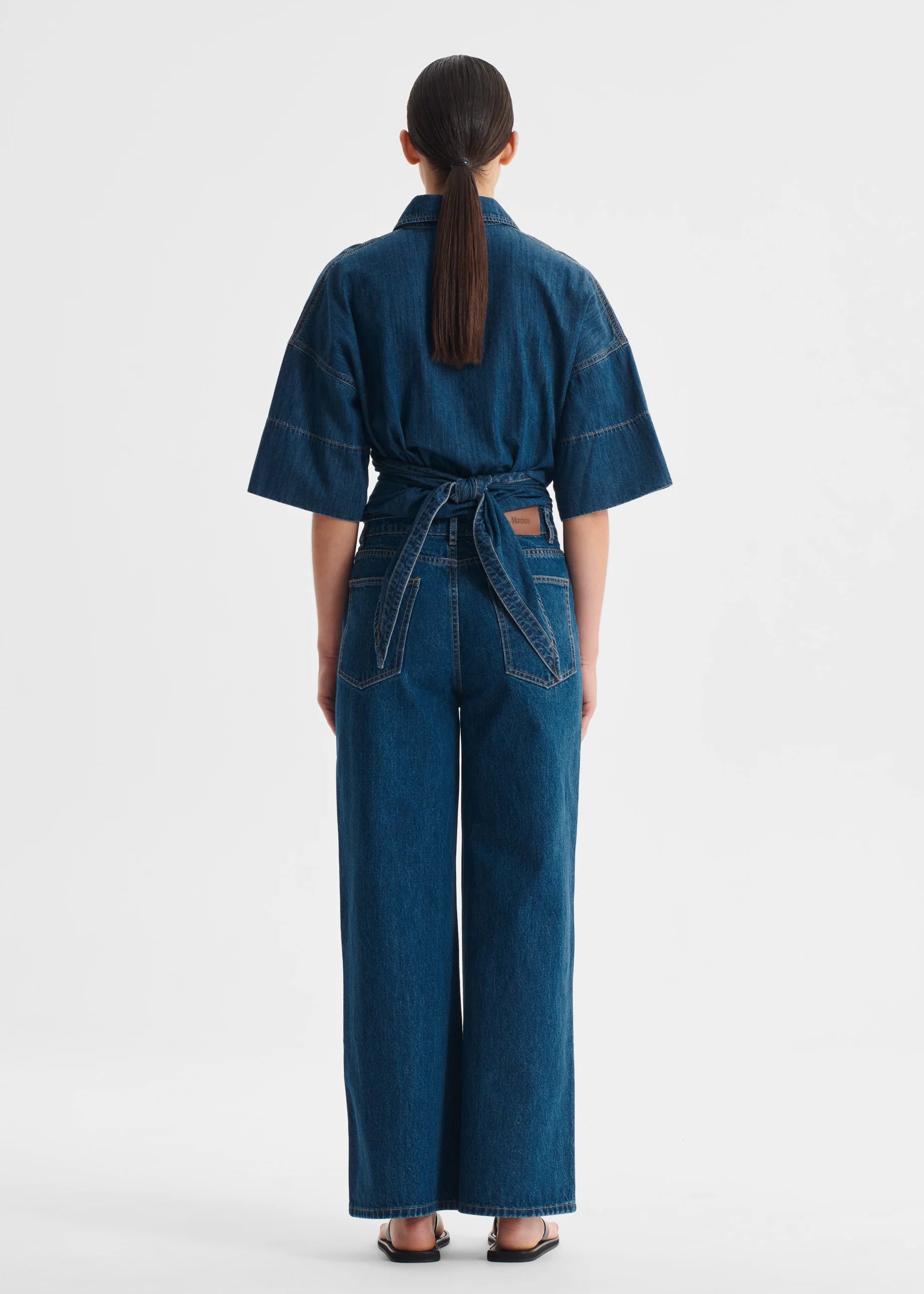Person wearing a blue denim top on a white background