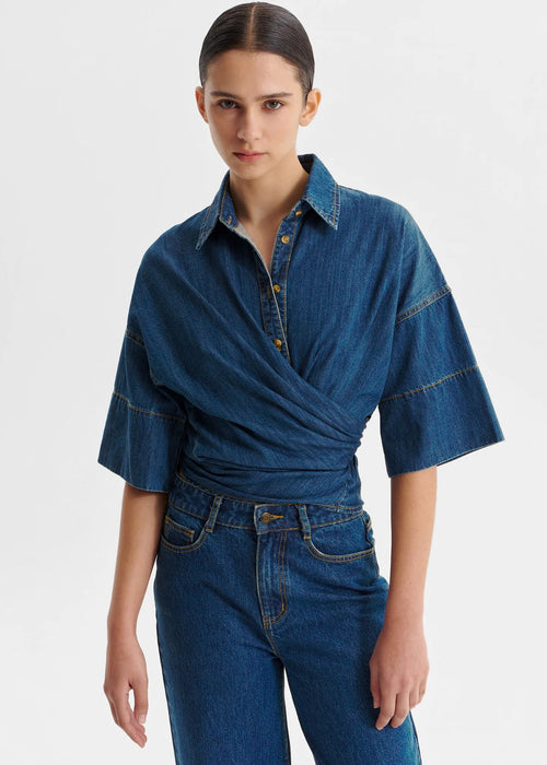 Woman wearing a blue denim top on a white background