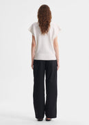 Woman wearing a white top and black pants on a white background