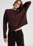 Woman wearing a maroon sweater against a plain background