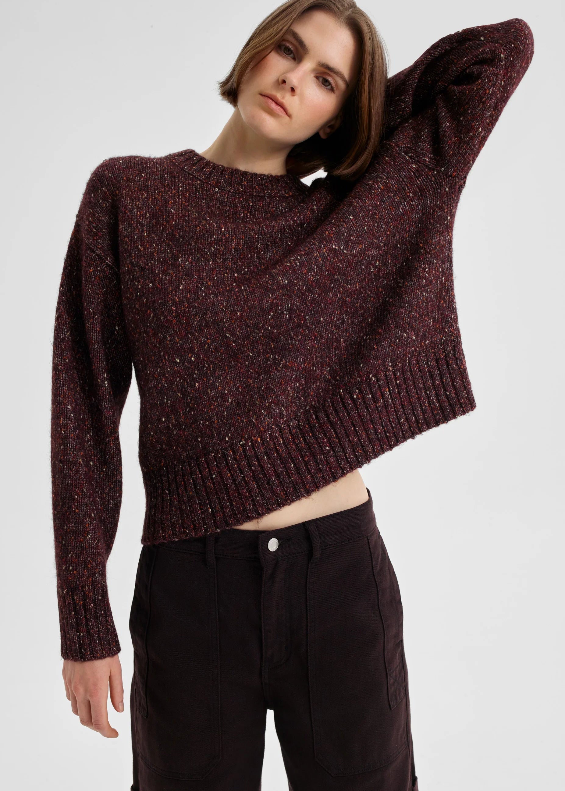 Woman wearing a maroon sweater against a plain background
