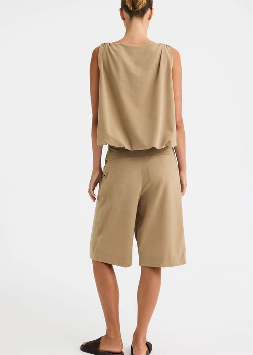 Woman shown from the back wearing brown knee length shorts