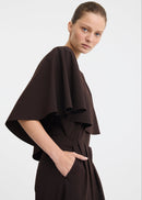 Woman wearing a brown top on white background