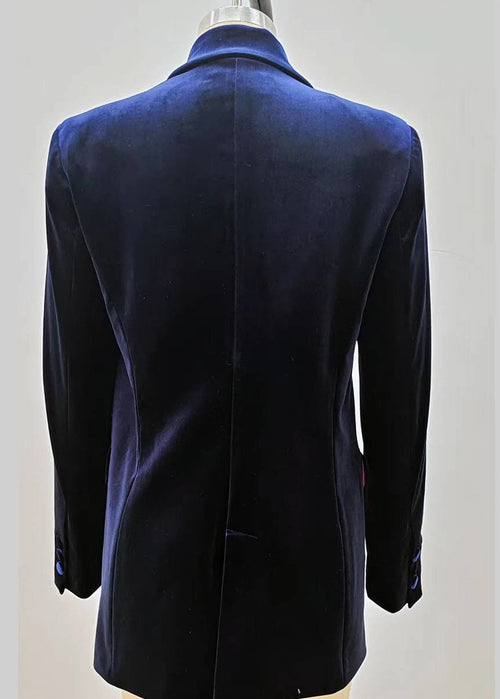 A dark navy blue velvet double-breasted blazer jacket displayed on a beige mannequin torso against a solid grey background.