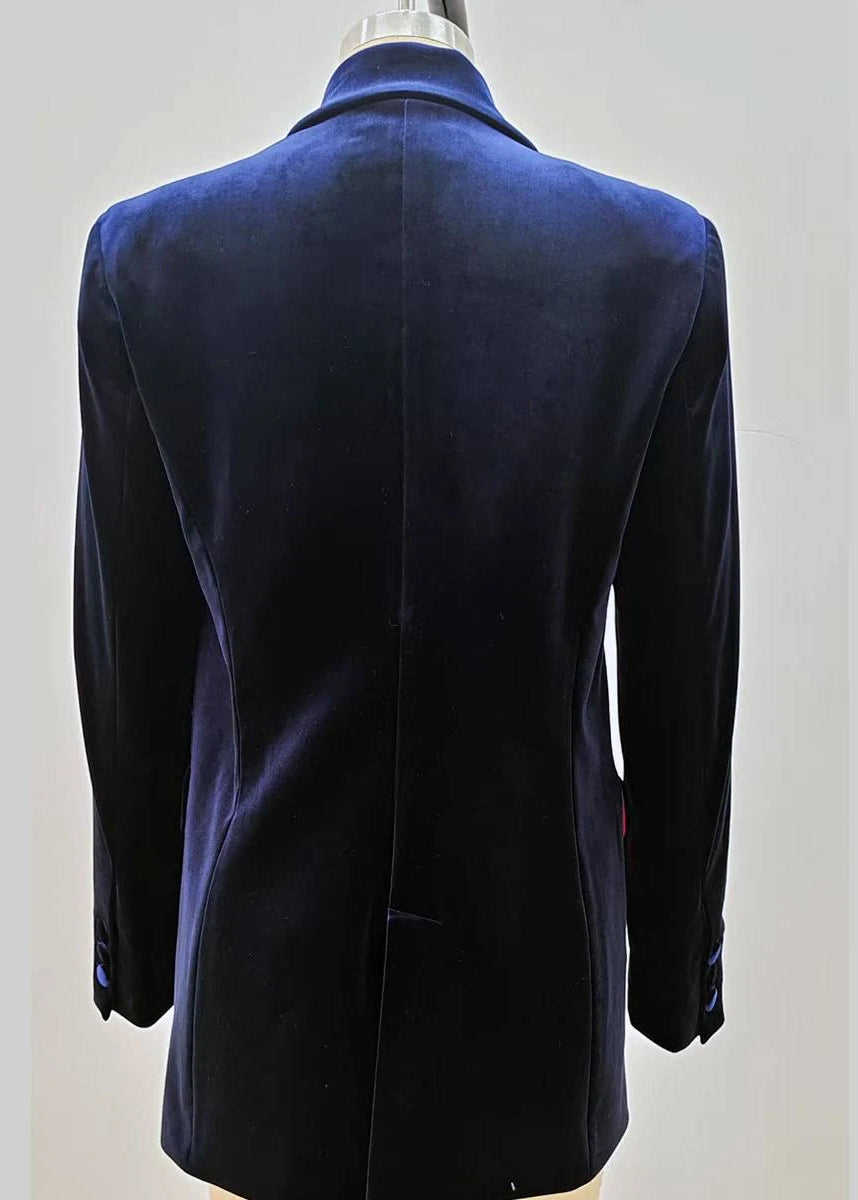 A dark navy blue velvet double-breasted blazer jacket displayed on a beige mannequin torso against a solid grey background.